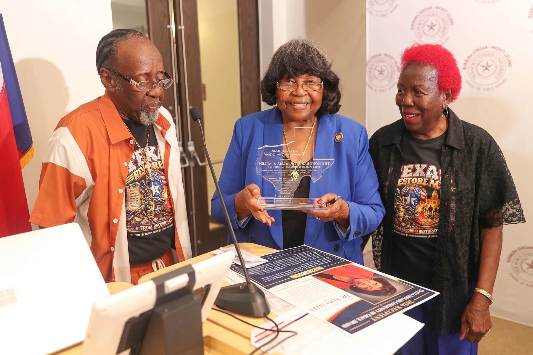 Dr. Alma A. Allen, wearing blue, receiving the 2026 Olivia Sholars Community of Grace Award during the award presentation.
